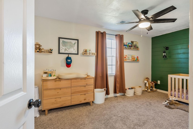 3355 Clearwater Dr, Clarksville, TN 37042 - bedroom featuring light colored carpet, a crib, wood walls, and a ceiling fan