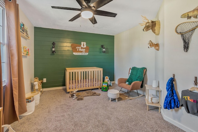 3355 Clearwater Dr, Clarksville, TN 37042 - bedroom with wooden walls, a crib, baseboards, ceiling fan, and carpet floors