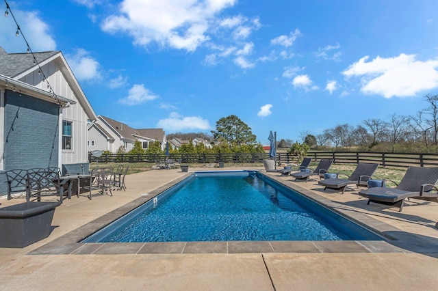 view of swimming pool featuring a fenced in pool, a patio, and fence