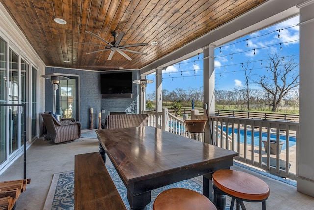 view of patio featuring a fenced in pool, outdoor dining space, and a ceiling fan