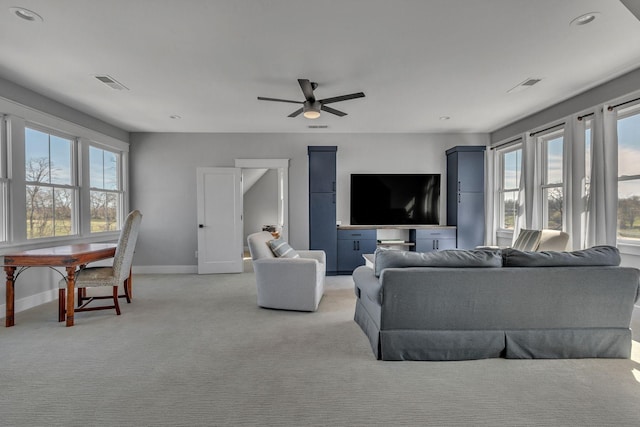 living area featuring a wealth of natural light, visible vents, and ceiling fan