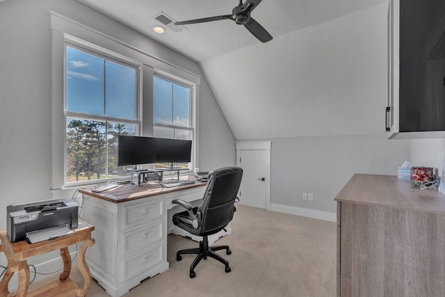 office space with baseboards, visible vents, ceiling fan, vaulted ceiling, and light colored carpet