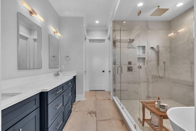 bathroom with double vanity, a freestanding tub, recessed lighting, a stall shower, and a sink