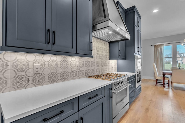 kitchen with premium range hood, light wood-style flooring, decorative backsplash, light countertops, and appliances with stainless steel finishes