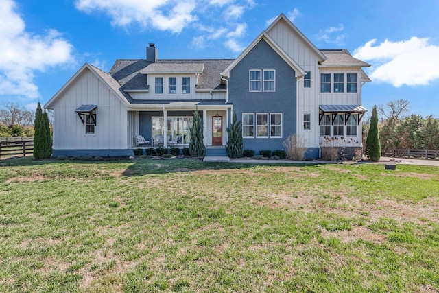 modern inspired farmhouse featuring a front yard, fence, board and batten siding, and a shingled roof