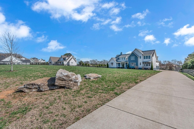 view of yard featuring driveway and fence