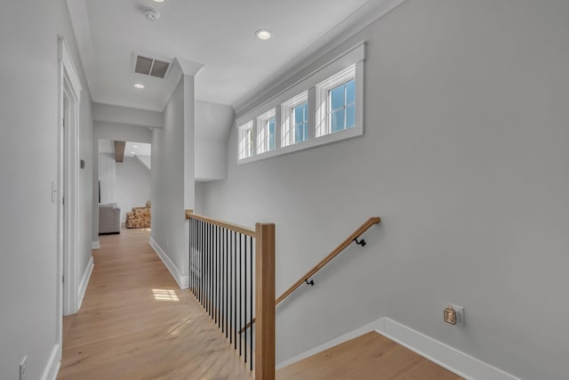 corridor featuring visible vents, baseboards, light wood-type flooring, an upstairs landing, and recessed lighting