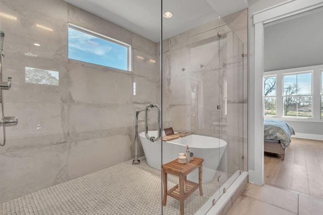 ensuite bathroom featuring a freestanding tub, a marble finish shower, ensuite bath, and tile patterned floors