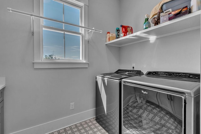 clothes washing area featuring washer and dryer, baseboards, laundry area, and tile patterned floors