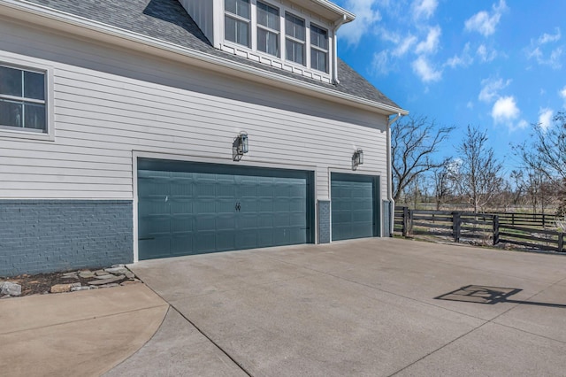 garage with driveway and fence