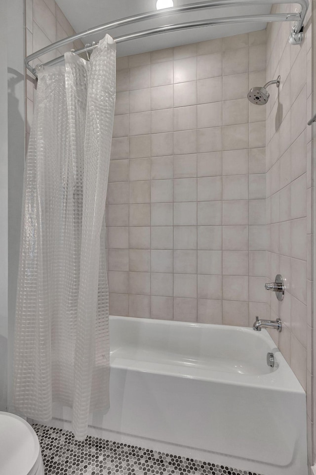 bathroom featuring tile patterned floors, toilet, and shower / bath combo with shower curtain