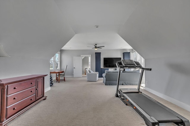 workout room featuring a ceiling fan, vaulted ceiling, light colored carpet, and baseboards
