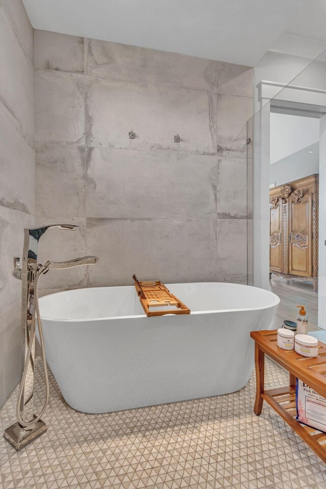 bathroom featuring a freestanding bath and tile walls