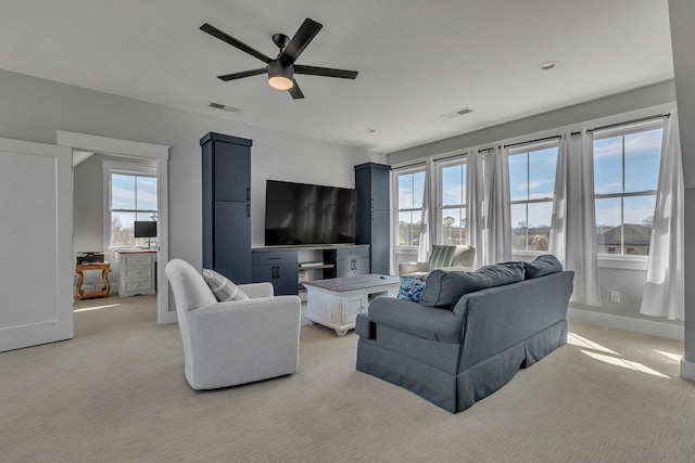living area featuring plenty of natural light, visible vents, and light carpet