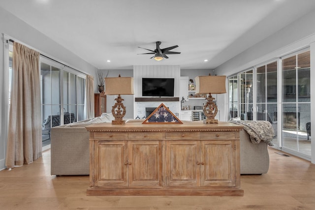 living area with recessed lighting, light wood-type flooring, and a ceiling fan