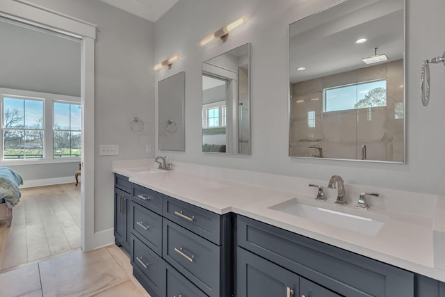 ensuite bathroom featuring double vanity, walk in shower, ensuite bathroom, and a sink