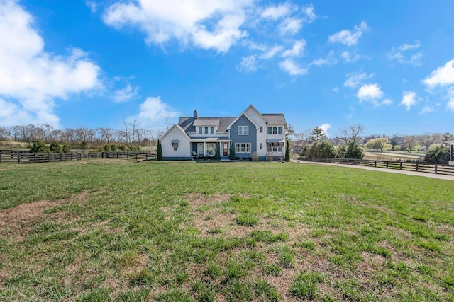 exterior space with a yard, a rural view, and fence