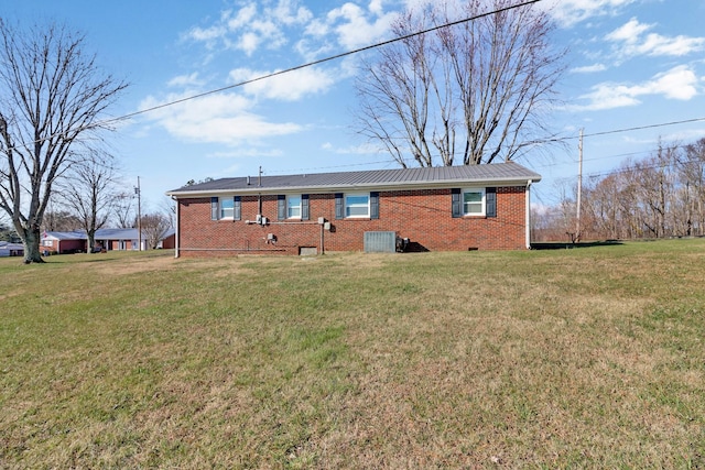 back of property with crawl space, a yard, brick siding, and central AC