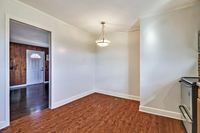 unfurnished dining area featuring visible vents, baseboards, wood finished floors, and ornamental molding