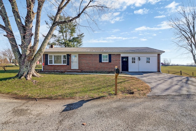 ranch-style house featuring a front lawn, brick siding, and aphalt driveway