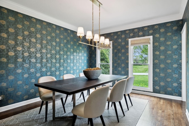 dining area with baseboards, an inviting chandelier, wallpapered walls, wood finished floors, and ornamental molding