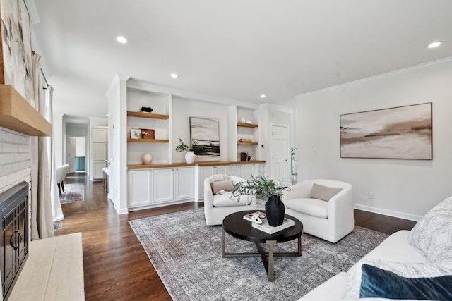 living area featuring crown molding, a fireplace, baseboards, dark wood-type flooring, and recessed lighting