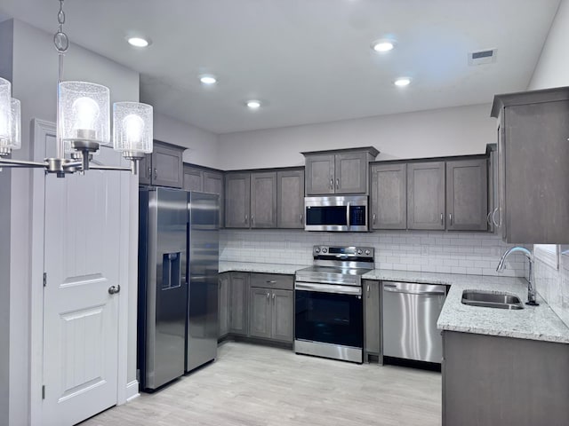 443 Generosity Way, Smyrna, TN 37167 - kitchen featuring stainless steel appliances, a sink, light wood-style flooring, decorative backsplash, and recessed lighting