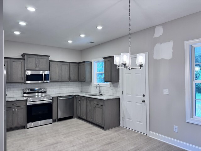 443 Generosity Way, Smyrna, TN 37167 - kitchen with appliances with stainless steel finishes, a sink, a chandelier, decorative backsplash, and light wood-style flooring