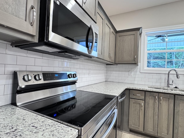 443 Generosity Way, Smyrna, TN 37167 - kitchen featuring appliances with stainless steel finishes, a sink, backsplash, light stone countertops, and dark brown cabinetry