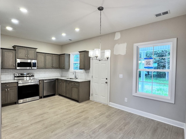 443 Generosity Way, Smyrna, TN 37167 - kitchen featuring appliances with stainless steel finishes, a sink, a chandelier, tasteful backsplash, and healthy amount of natural light