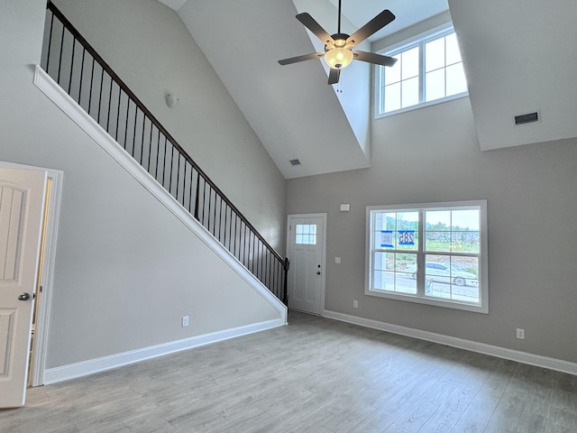 443 Generosity Way, Smyrna, TN 37167 - unfurnished living room featuring a towering ceiling, stairs, ceiling fan, wood finished floors, and baseboards