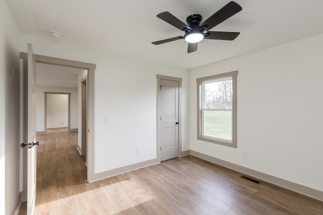 unfurnished bedroom with ceiling fan, light wood-style floors, visible vents, and baseboards