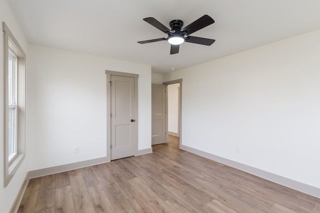 empty room with light wood finished floors, ceiling fan, and baseboards