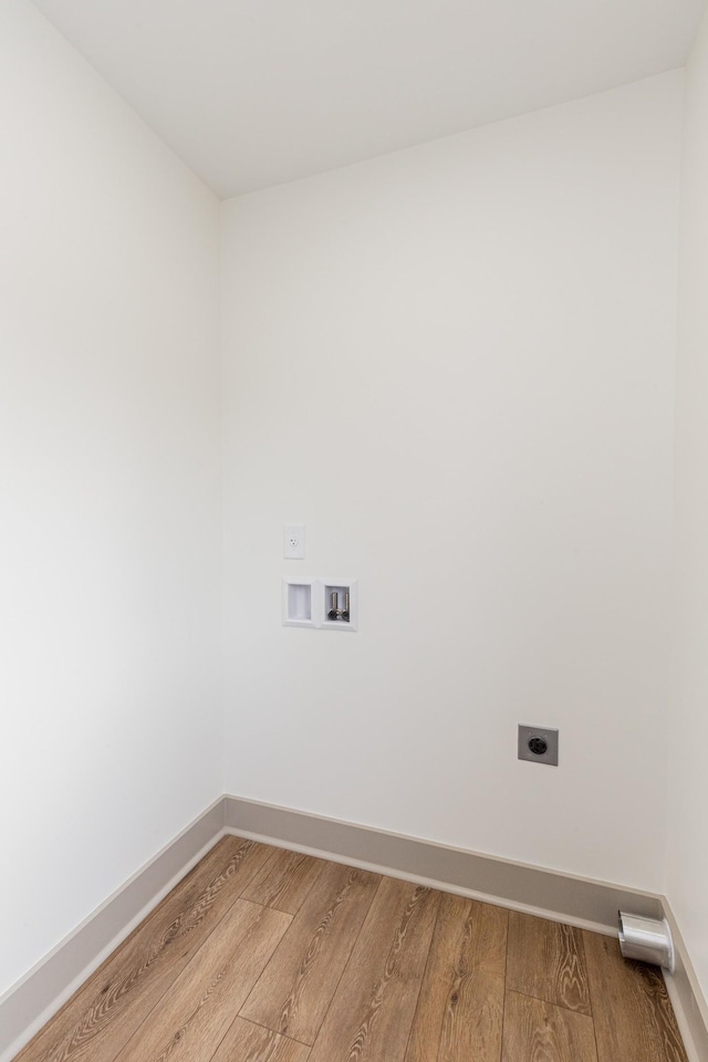 laundry room with electric dryer hookup, washer hookup, hardwood / wood-style flooring, baseboards, and laundry area