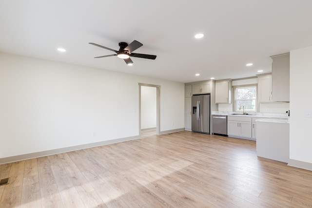 kitchen featuring light countertops, recessed lighting, light wood-style floors, stainless steel appliances, and a sink