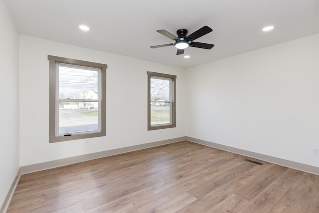spare room featuring recessed lighting, light wood-type flooring, and baseboards