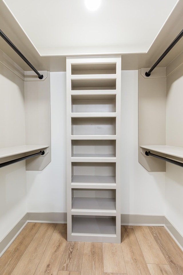 spacious closet with radiator heating unit and wood finished floors