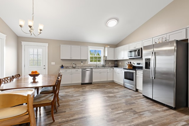 2619 Prospect Rd, Dalton, GA 30721 - kitchen featuring light wood finished floors, lofted ceiling, stainless steel appliances, a notable chandelier, and white cabinetry