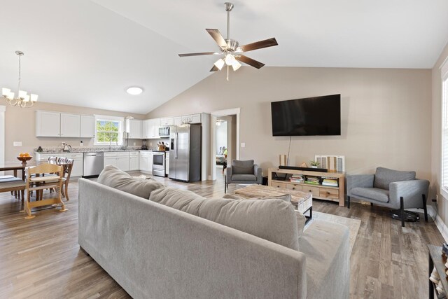 2619 Prospect Rd, Dalton, GA 30721 - living room with ceiling fan with notable chandelier, light wood-type flooring, and vaulted ceiling