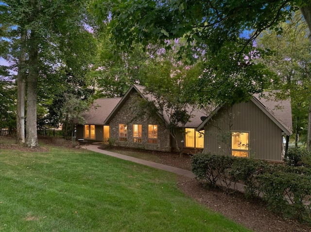 view of front facade featuring a front lawn and stone siding
