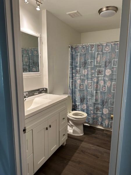 854 Todd Preis Dr, Nashville, TN 37221 - full bath with vanity, a shower with shower curtain, wood finished floors, visible vents, and toilet