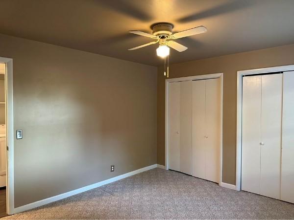 854 Todd Preis Dr, Nashville, TN 37221 - unfurnished bedroom with baseboards, multiple closets, light carpet, and a ceiling fan
