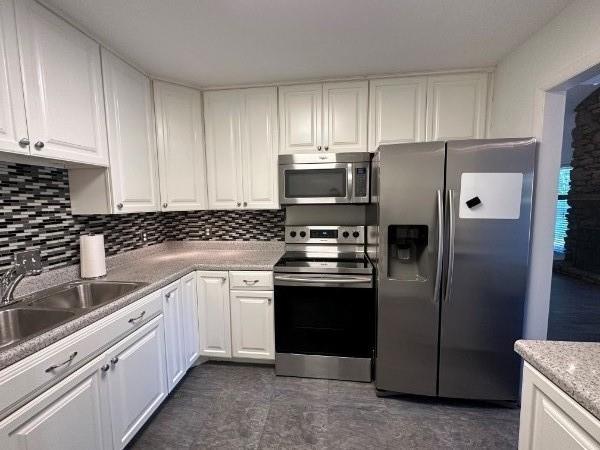 854 Todd Preis Dr, Nashville, TN 37221 - kitchen with decorative backsplash, white cabinets, and stainless steel appliances