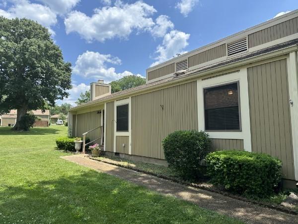 854 Todd Preis Dr, Nashville, TN 37221 - view of home's exterior with a lawn and a chimney