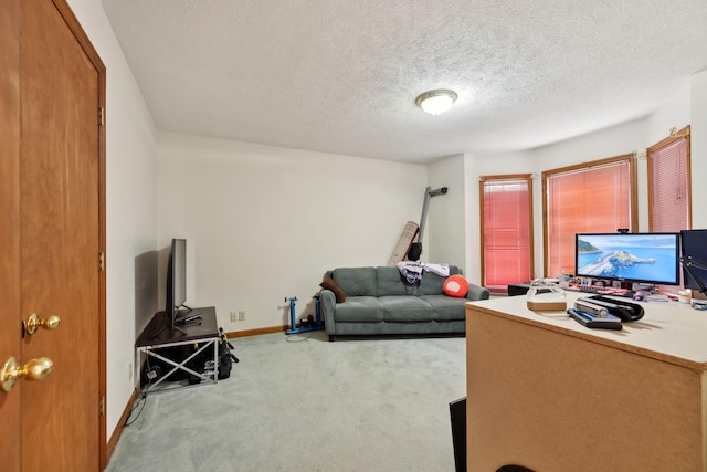 carpeted office featuring a textured ceiling and baseboards