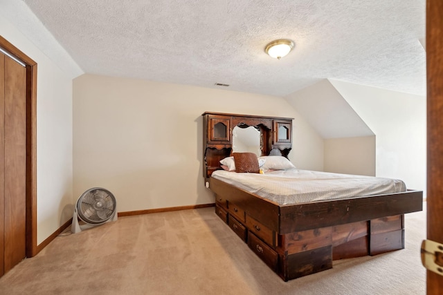 bedroom featuring light colored carpet, a textured ceiling, baseboards, and lofted ceiling