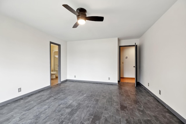 unfurnished room featuring baseboards, dark wood-type flooring, and ceiling fan