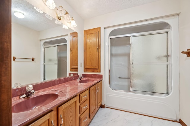 full bath featuring a sink, a textured ceiling, and marble finish floor