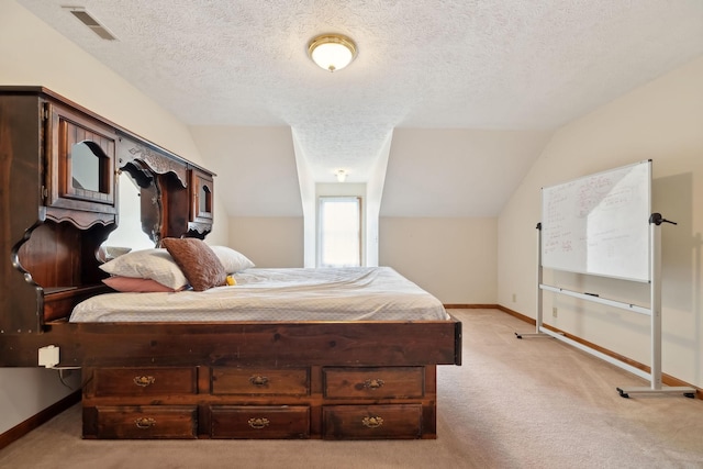 bedroom featuring light carpet, visible vents, a textured ceiling, and baseboards