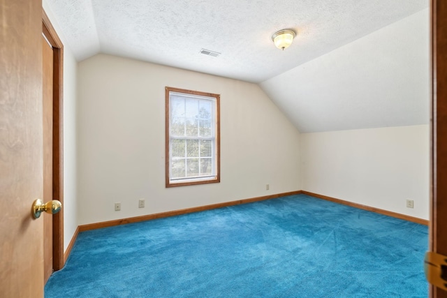 bonus room featuring lofted ceiling, baseboards, visible vents, and a textured ceiling